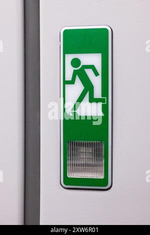 Emergency exit on an aircraft, view from inside of the plane. Exit Sign in a passenger plane. Emergency exit sign on the wall inside the airplane. Saf Stock Photo