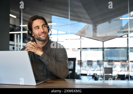 Happy young professional man call contact center agent working in office. Stock Photo