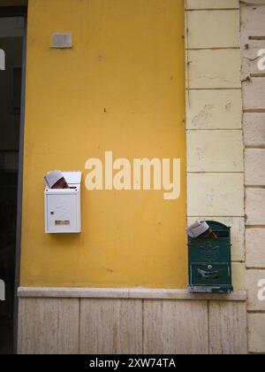 Vertical Close-Up of Two Mailboxes on a Yellow Wall in Olbia’s Historic Center Stock Photo