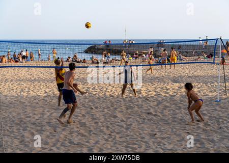 People Playing Volleyball on Platja De La Fragata in Sitges, Spain Stock Photo