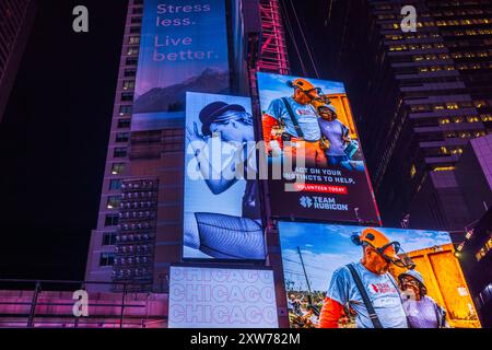 Close up view of Broadway, New York at night with skyscrapers featuring LED billboards for 'Chicago' musical. New York. USA. Stock Photo