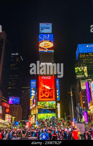 Night view of Times Square skyscraper with LED panels displaying advertisements for Coca-Cola, Samsung, and other brands. New York. USA. Stock Photo