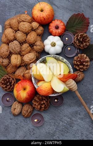 Rosh Hashanah symbols top view photo. Red apples, honey, decorations and candles on textured background with copy space. Culture of Israel concept. Stock Photo