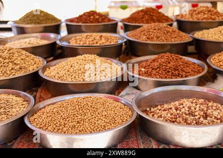 Many different nuts in large metal vices on the counter of a local bazaar Stock Photo