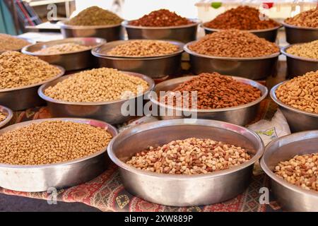 Many different nuts in large metal vices on the counter of a local bazaar Stock Photo