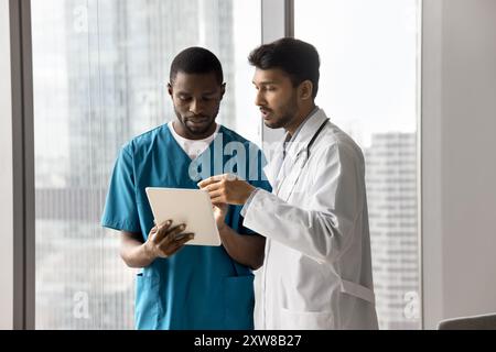 Two medical professionals collaborating, examining information on tablet Stock Photo