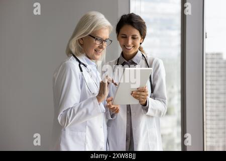 Doctors using tablet, review e-health application, think on treatment plan Stock Photo