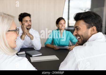 Therapists laughing, looking at each other engaged in medical seminar Stock Photo