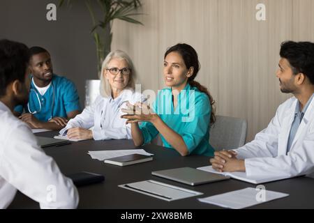 Diverse doctors engaged in seminar interaction in meeting room Stock Photo