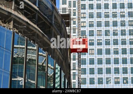 London, England, UK - 21 June 2022: Elevator for construction workers operating on the side of a new office building in central London Stock Photo
