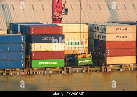 Puerto Quetzal, Guatemala - 19 January 2024: Crane lifting a shipping container from a ship  in the the country's main sea port. Stock Photo