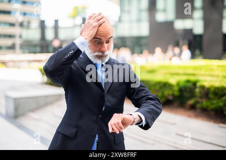 Surprised businessman checking his wrist watch Stock Photo