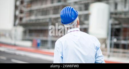 Detail of an architect site manager from behind in front of construction site Stock Photo