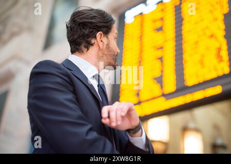 Commuter checking time in front of a timetable Stock Photo