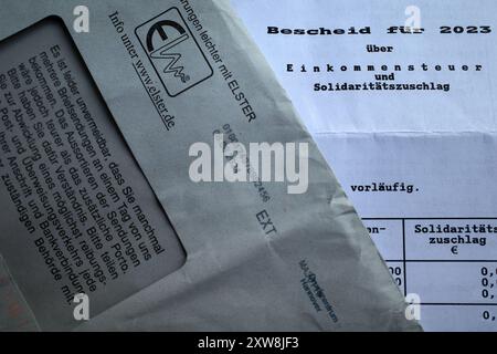 Itterbeck, Germany - Aug 14 2024 Part of a german income tax notice over 2023 and the accompanying envelope Stock Photo