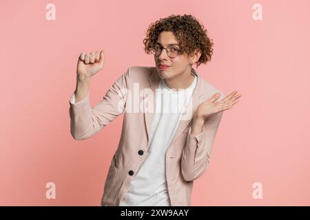 Knock-knock who is there. Confused excited Caucasian curly haired man in jacket knocking door gesture asking who is at home, feeling embarrassed no idea being clueless and uncertain on pink background Stock Photo