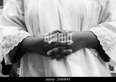 Salvador, Bahia, Brazil - July 27, 2019: Detail, in black and white, of the hands of a Catholic faithful during the procession in the historic center Stock Photo