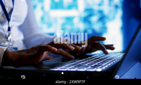 Trained specialist using laptop to maintenance artificial intelligence neural networks made up of artificial neurons. System administrator using AI system aiding in processing information, close up Stock Photo