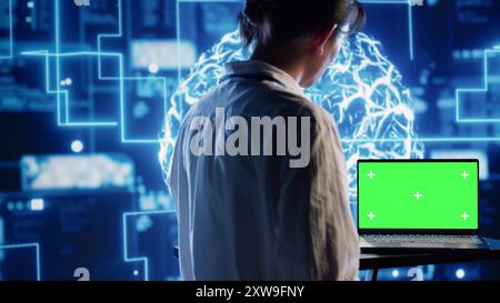 Developer using green screen laptop to implement artificial intelligence parallel processing, breaking up complex computational tasks enabling AI systems to process more input data faster Stock Photo