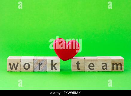 Heart resting on wooden cubes with the words work and team Stock Photo