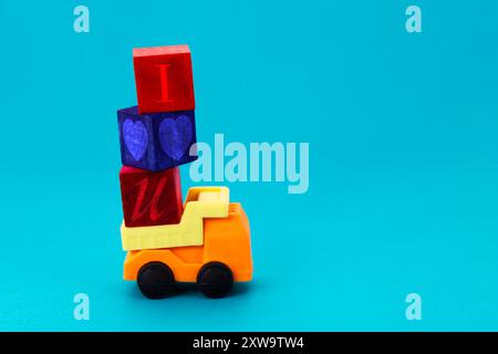 Truck transporting colorful wooden cubes with love phrase Stock Photo