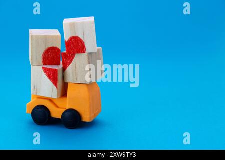 Truck transporting wooden cubes that form a heart Stock Photo