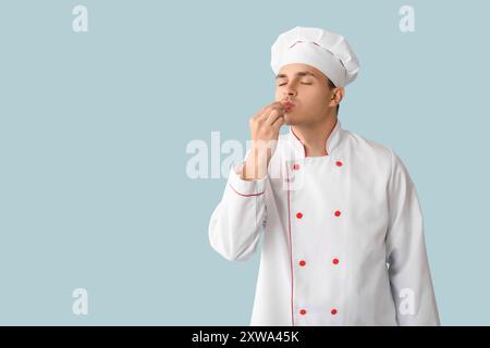 Handsome male chef showing perfect gesture on blue background Stock Photo