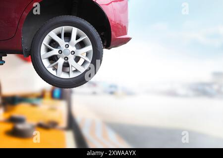 Close up of car wheels on hydraulic lift in car service center with copy space, car repair service center concept. Stock Photo