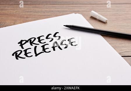 Press release handwritten on a white sheet of paper. Public announcement and press release concept. Stock Photo