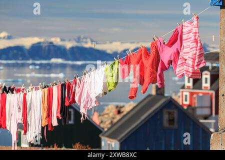 Typical greenlandic houses at a fjord with icebergs and mountains, sunny, Ittoqqortoormiit, Scoresby Sund, East Greenland, Greenland Stock Photo