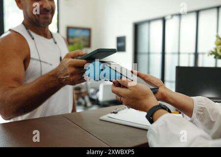 Man Paying With Smartphone For Sport Training Stock Photo