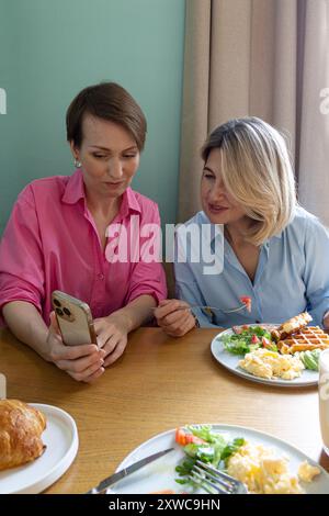 two business women have breakfast in a cafe Stock Photo