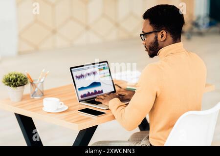 Black manager working with diagrams on pc Stock Photo