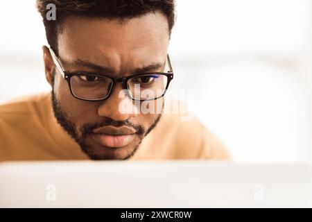 Headshot of afro man working on laptop Stock Photo