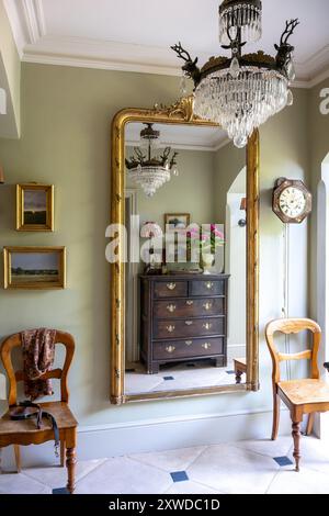 Gilt framed mirror in 'Ball green' hall with limestone tiles in Wimbledon home, south-west London, England, UK. Stock Photo