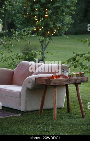 Cozy sofa on a green lawn on a summer's night in Sweden. Stock Photo