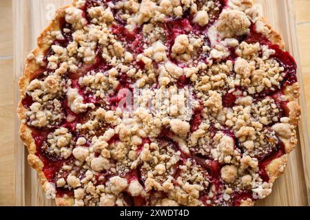 A homemade plum crumble cake on a wooden board. Stock Photo