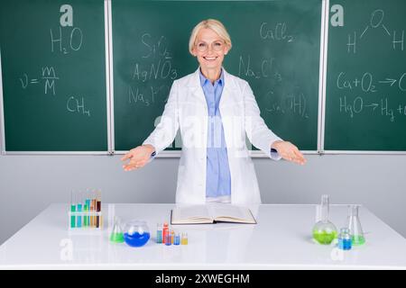 Photo of charming smart intelligent professor lady wear white coat doing chemical experiment isolated on green board background Stock Photo