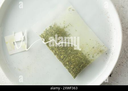 A top down view of a tea bag filled with green tea. Stock Photo