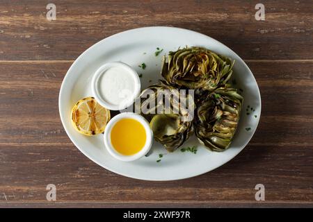A top down view of a plate of grilled artichokes. Stock Photo