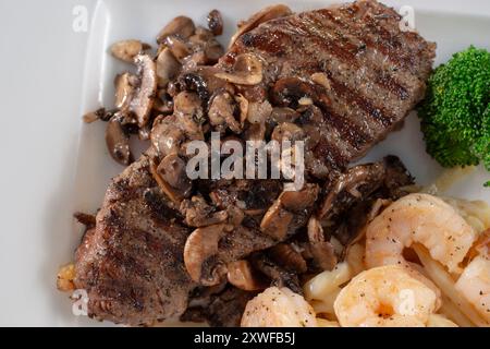 A top down view of a New York steak topped with mushrooms. Stock Photo