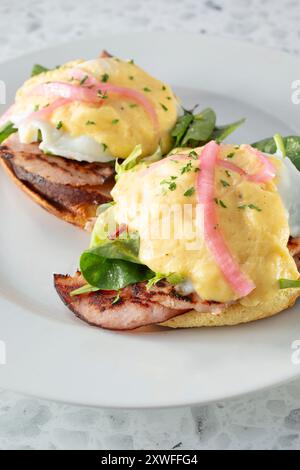 A closeup view of a plate of eggs Benedict on pancakes. Stock Photo
