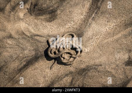 A close up abstract HDR of patterns in the pale and dark sand left by the receding tide, North Uist, Outer Hebrides, Scotland. 05 August 2024 Stock Photo