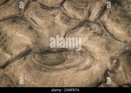 A close up abstract HDR of patterns in the pale and dark sand left by the receding tide, North Uist, Outer Hebrides, Scotland. 05 August 2024 Stock Photo