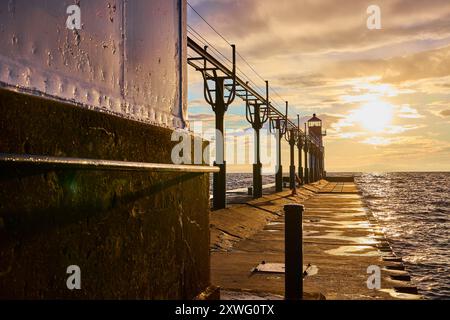 Golden Hour Lighthouse on Pier with Glistening Water Perspective Stock Photo