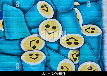 Vibrant Smiley Faces Mural on Brick Wall Eye-Level Perspective Stock Photo