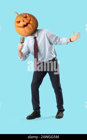 Businessman with Halloween pumpkin instead of his head singing on blue background Stock Photo