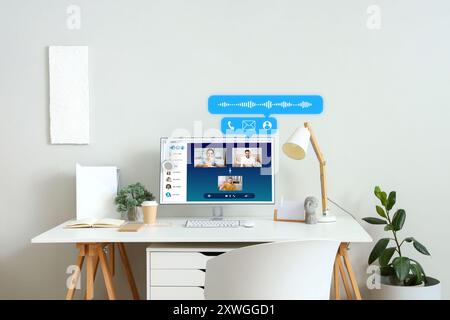 Interface of software used by people for video chatting on screen of computer monitor on table Stock Photo