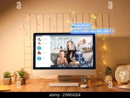 Interface of software used by people for video chatting on screen of computer monitor on table Stock Photo