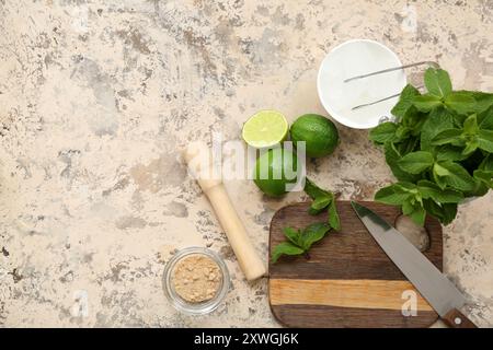 Wooden cutting board, pestle, knife and ingredients for preparing mojito on grunge background Stock Photo